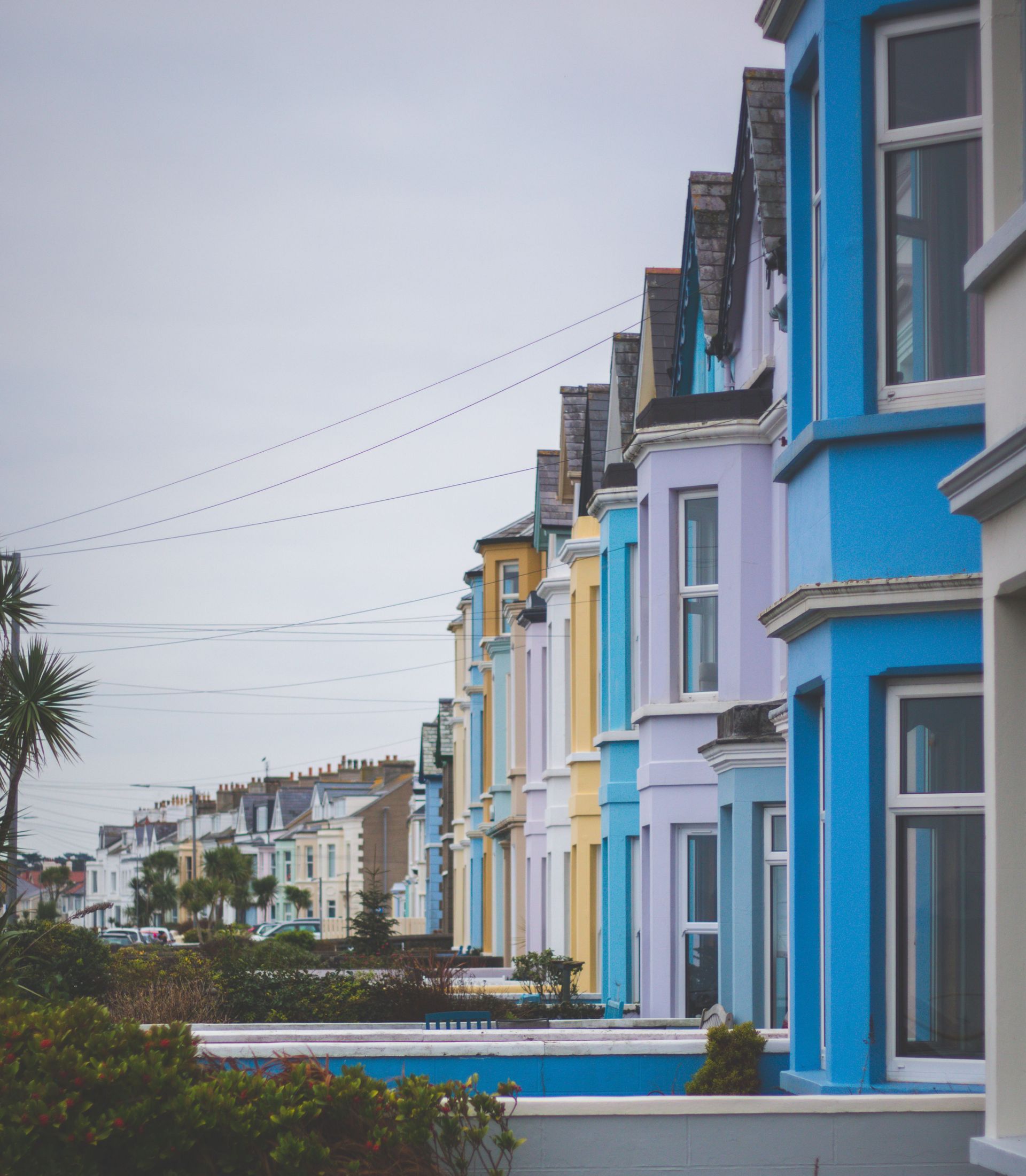 A vibrant row of Victorian houses showcasing colorful exteriors in an urban setting.